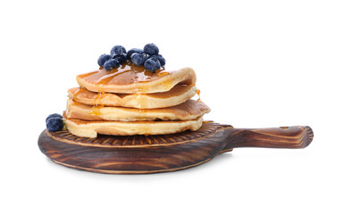 Board with tasty pancakes and blueberries on white background