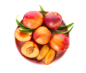 Plate with fresh peaches on white background