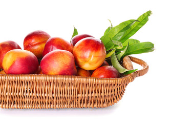 Basket with fresh peaches on white background