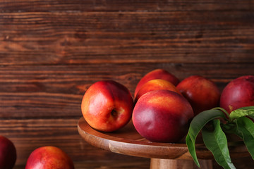 Stand with fresh peaches on wooden background