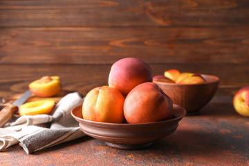 Bowl with fresh peaches on table