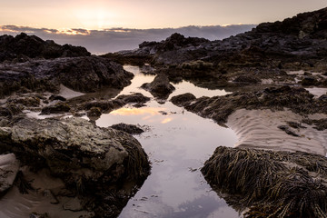 low tide river leading to rocks and the ocean