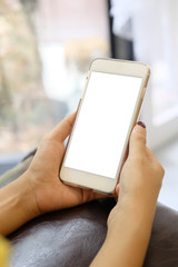 Close up hands holding mockup mobile smartphone with white screen.