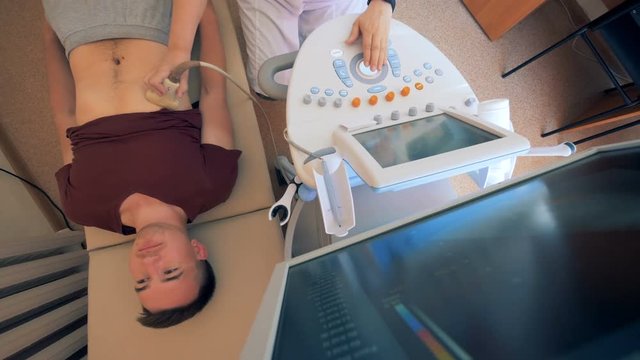 Male patient lying on a hospital bed and going through ultrasonic test