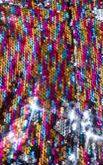 Sequins close-up macro. Abstract background with sequins colorful on the fabric. Texture scales of round sequins 