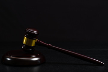 Law or auction gavel on a wooden office desk.