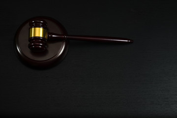 Law or auction gavel on a wooden office desk.
