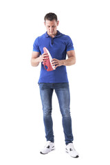 Front view of adult male shopper holding and choosing right sneakers. Full body isolated on white background. 