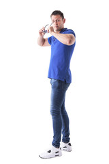 Side view of upset young adult man removing sunglasses and looking at camera. Full body isolated on white background. 