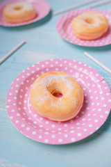 Party. Different colourful sugary round glazed donuts and bottles of drinks on light color background.