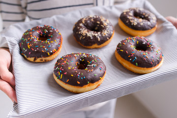 Male hands holding a tray of donuts