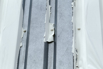 External cladding coating dis bonding and flaking off exposing the galvanised steel profiled panels.