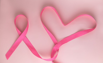 Pink ribbon and Heart on pink background as symbol of female breast disease. Breast cancer month awareness tape. Minimalistic style. Top view. Flet lei. Place for text. Copy space. © tumana_net