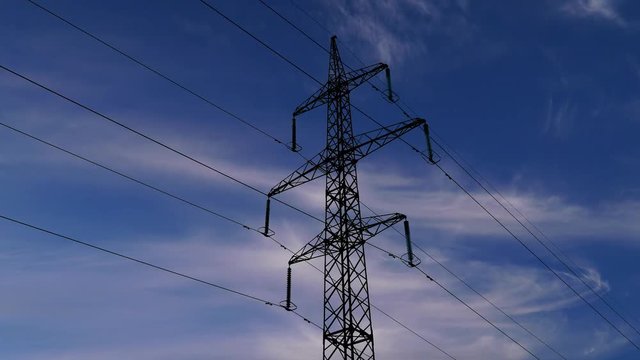Electricity pylons and clouds sky on the background. Timelapse. Zoom out 4K