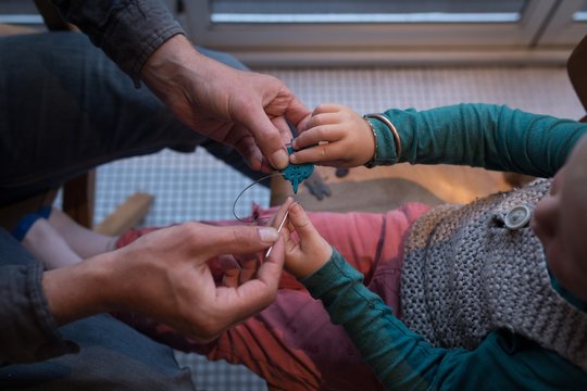 Father teaching his son about pin and thread