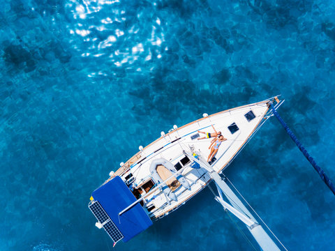 Aerial view to Yacht in deep blue sea. Drone photography