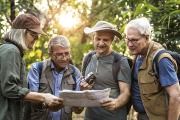 Group of senior trekkers checking a map for direction