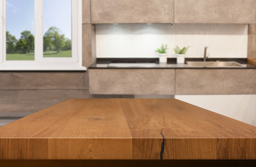 Kitchen, background. Empty textured wooden table and kitchen window shelves blurred background