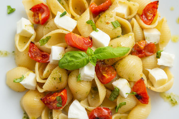 Pasta alla caprese, italian pasta with mozzarella, tomatoes and frtesh basil 