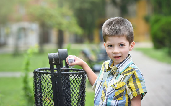 little boy throwing garbage outdoor