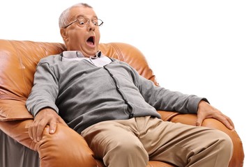 Terrified mature man sitting in an armchair