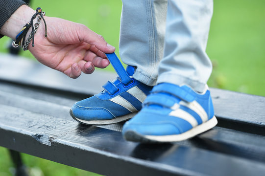 Man Tying Velcro Snickers On Child