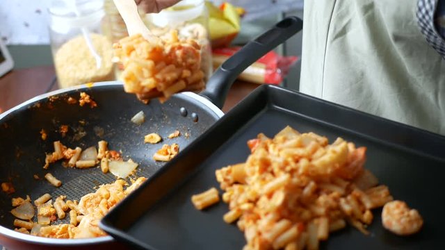 4K footage. woman hand take the macaroni scoop from the pan into the dish and serve after finish cooking.