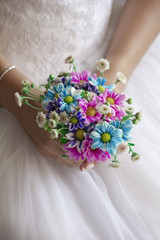 Bride holding colored flowers bouquet