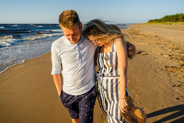 portrait of young couple in love walking on sandy beach in Riga, Latvia