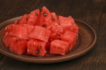The flesh of watermelon cut into cubes in a clay plate