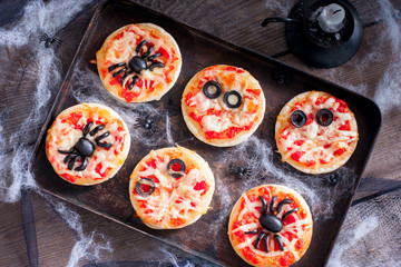 Mini pizza for Halloween with spiders, mummy and spider web, horizontal