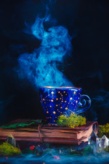 Ceramic cup with constellations and stars in a magical still life. Astronomer or astrologer...