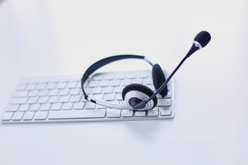 Communication support, call center and customer service help desk. VOIP headset on laptop computer keyboard