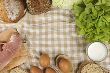 Set products consisting of bread, milk, pork, eggs , and vegetable on wooden table background, fresh food for cooking