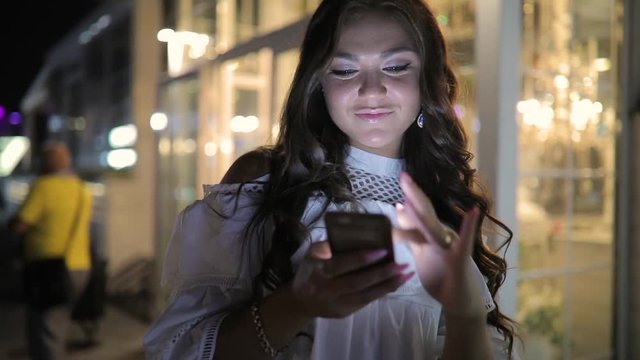 Woman browsing smartphone using app in night city
