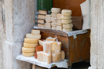 Truffle cheese and other cheeses are for sale in an alley.