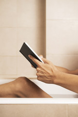 young man reading a book in the bathtub