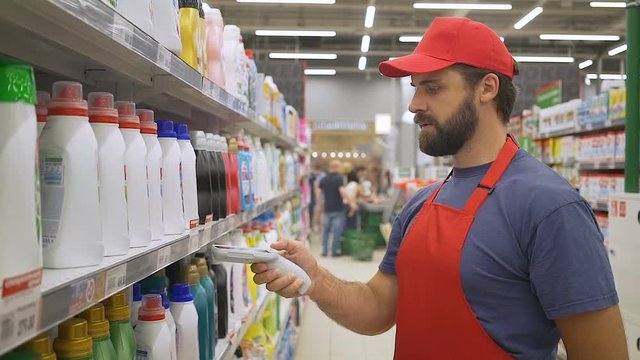 sales clerk in red uniform scanning cleaners barcode in supermarket