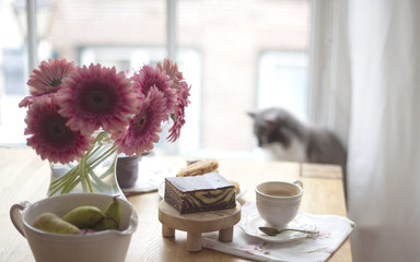 A large bouquet of white flowers on the table and breakfast for the family. Cozy house and delicious food. Seasonal Fruits, pastries and fragrant coffee. Copy space,