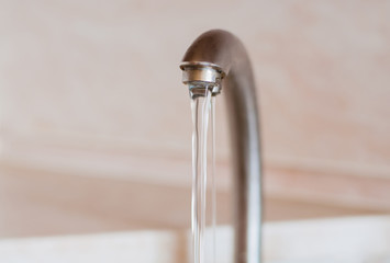 Water frowing faucet. Water running from the kitchen tap. Concept of water consumption