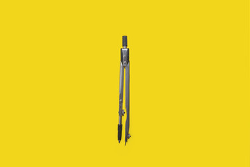 calipers lying on a yellow background . concept of office supplies. free space for advertising text