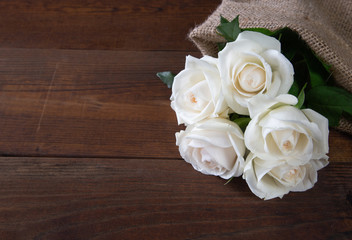 Bunch of beautiful white roses on wooden background