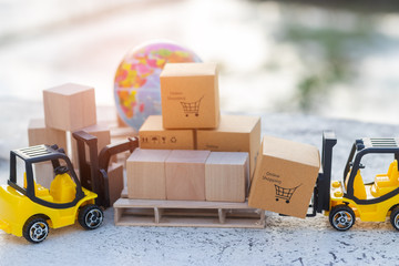 Mini forklift truck load cardboard box with shopping cart symbol on wooden pallet and globe near...