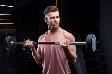 Fototapeta na wymiar Guy bodybuilder in the gym shakes muscles. Top view, copy space