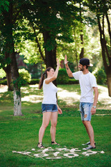 A young couple celebrate victory playing tic-tac-toe in the park