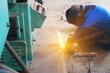 The welder at the industrial plant makes the connection using an electric arc.