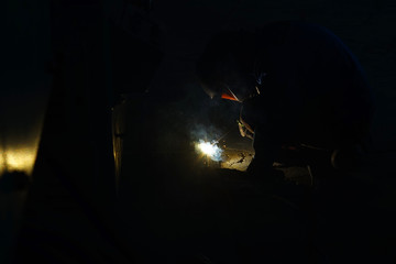 The welder at the industrial plant makes the connection using an electric arc.