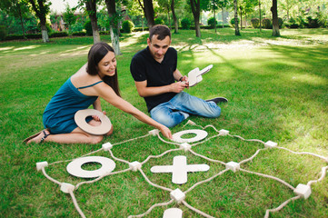 Friends playing tic-tac-toe on green grass