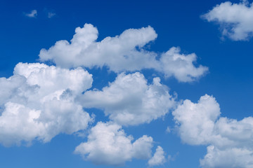 White fluffy clouds in the vast blue sky. Abstract nature background.