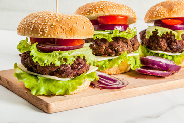 Fast food. Unhealthy food. Delicious Fresh Tasty Burgers with Beef Cutlet, fresh Vegetables and Cheese on white background. Copy space